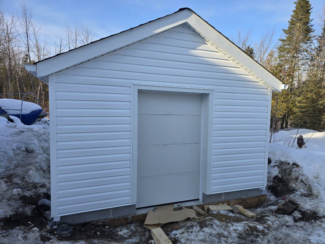 White horizontal siding and trim around a garage door and gable.